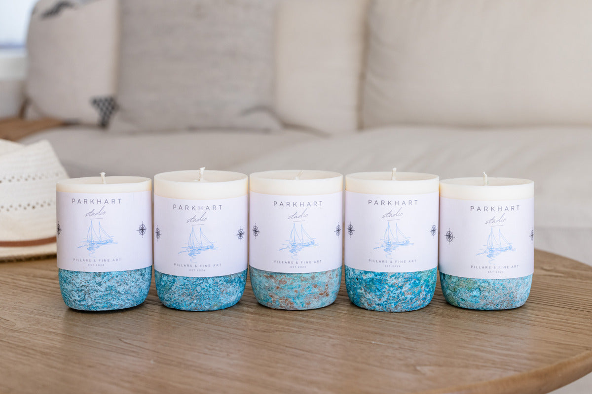 Five candles with blue glittery base and white cap on a wooden table.
